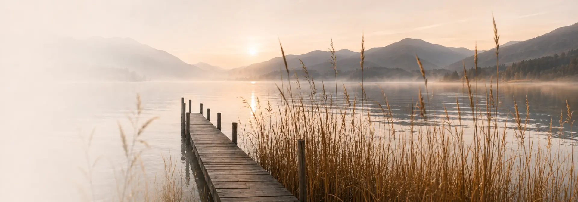 Steg über ruhigem Wasser in heller Landschaft